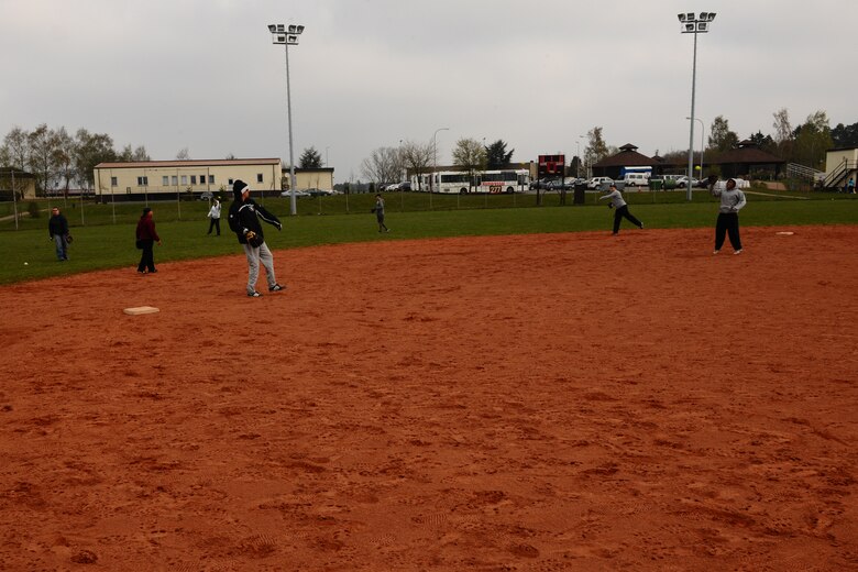 SPANGDAHLEM AIR BASE, Germany – Team members throw softballs to one another to warm up before a softball game on Field 1 here April 15. The first 52nd Maintenance Operations Squadron sponsored softball tournament included more than 12 teams made up of military and family members 18 and older and is intended to prepare players for the upcoming intramural season. The 52nd Civil Engineer Squadron team beat the 470th Air Base Squadron 19-17 in the final game of the double-elimination tournament. (U.S. Air Force photo by Airman 1st Class Dillon Davis/Released)