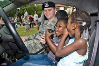 Julionne and Amora Graham Harper sit in one of the police cruisers while making calls on the police radio at the annual Famaganza celebration April 14th at Joint Base San Antonio-Randolph, Texas. Famaganza is a yearly family celebration that includes performances, games, prizes and a book fair. (U.S. Air Force photo by Benjamin Faske)