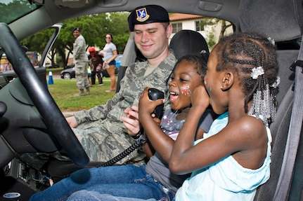 Julionne and Amora Graham Harper sit in one of the police cruisers while making calls on the police radio at the annual Famaganza celebration April 14th at Joint Base San Antonio-Randolph, Texas. Famaganza is a yearly family celebration that includes performances, games, prizes and a book fair. (U.S. Air Force photo by Benjamin Faske)