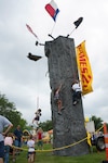 Children race each other on the three-story climbing wall at the annual Famaganza celebration April 14 at Joint Base San Antonio-Randolph, Texas. Famaganza is a yearly family celebration that includes performances, games, prizes and a book fair. (U.S. Air Force photo by Benjamin Faske)