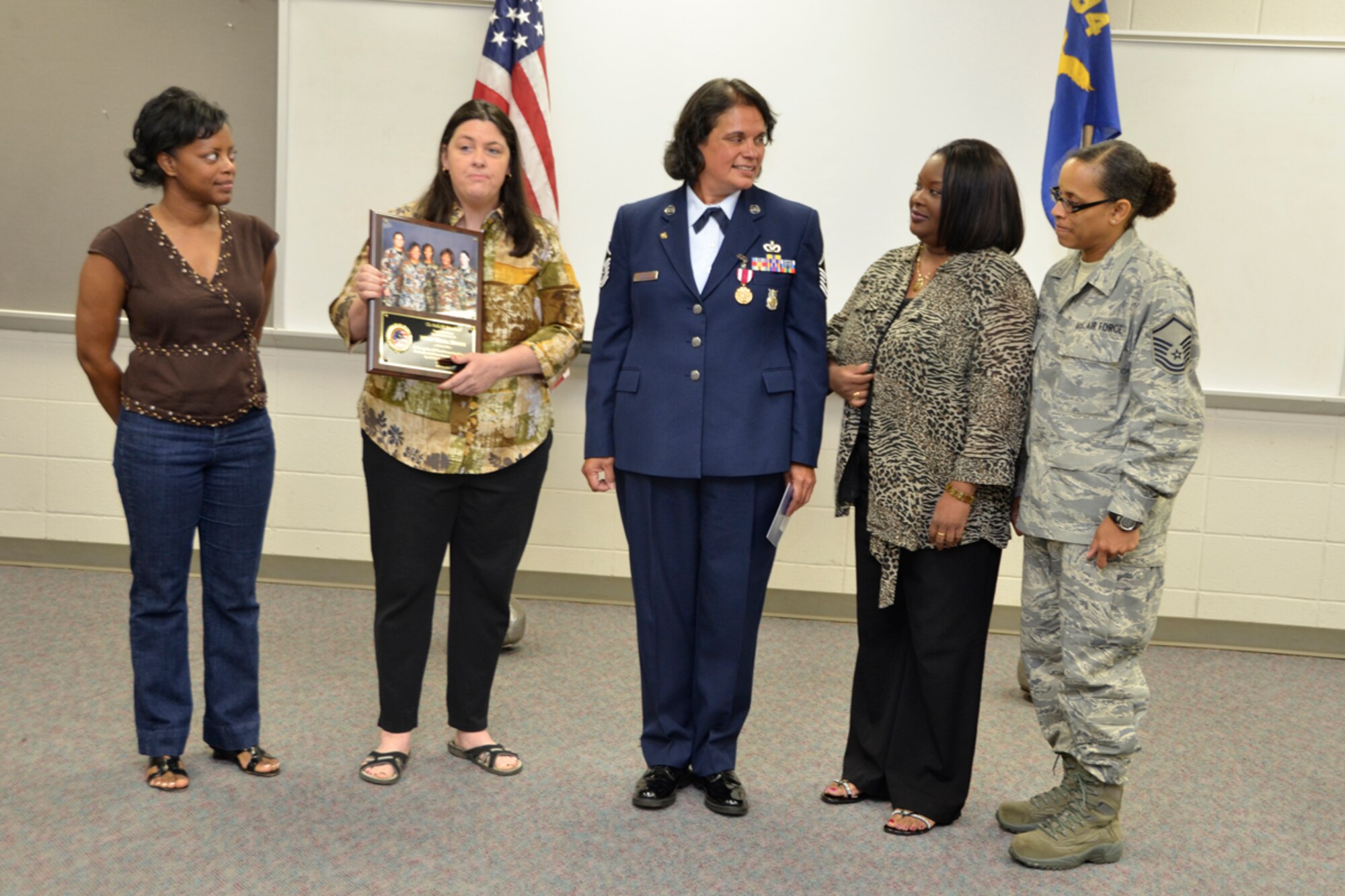 Former members of the 94th Civil Engineer Squadron present Master Sgt. Hilda Elaine Moses, 94th CES health and safety officer, with a token of sisterhood, during her retirement ceremony, April 14. Moses celebrated 23 years of dedicated service to the U.S. Air Force. (U.S. Air Force photo/Master Sgt. James Branch)