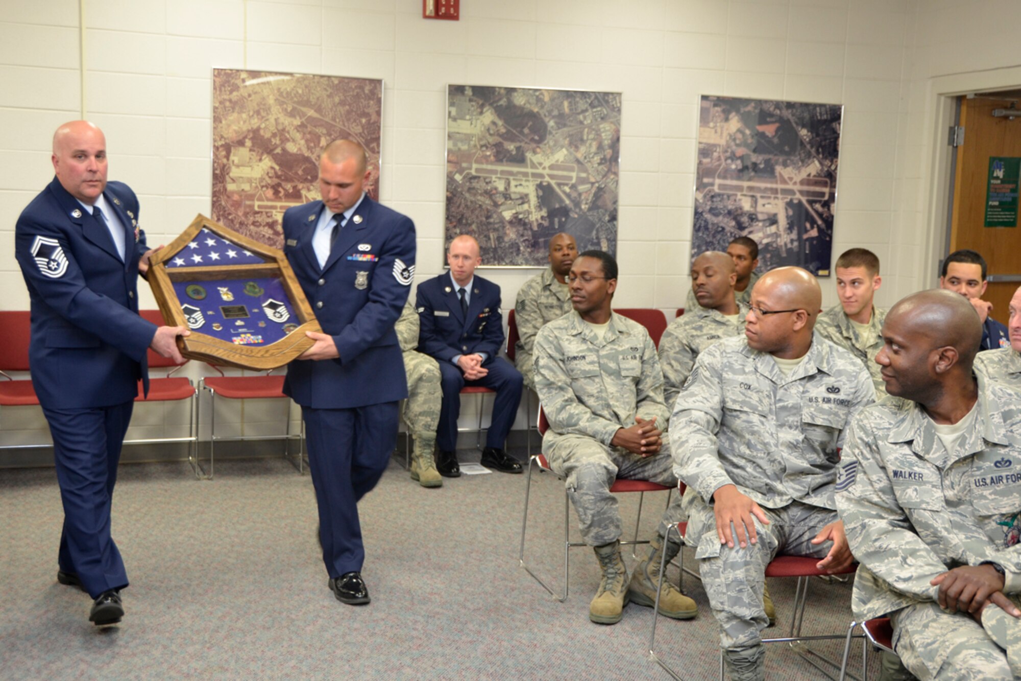 Members of the 94th Civil Engineer Squadron present Master Sgt. Hilda Elaine Moses, 94th CES health and safety officer, with a shadow box highlighting her career, during her retirement ceremony, April 14. Moses celebrated 23 years of dedicated service to the U.S. Air Force. (U.S. Air Force photo/Master Sgt. James Branch)
