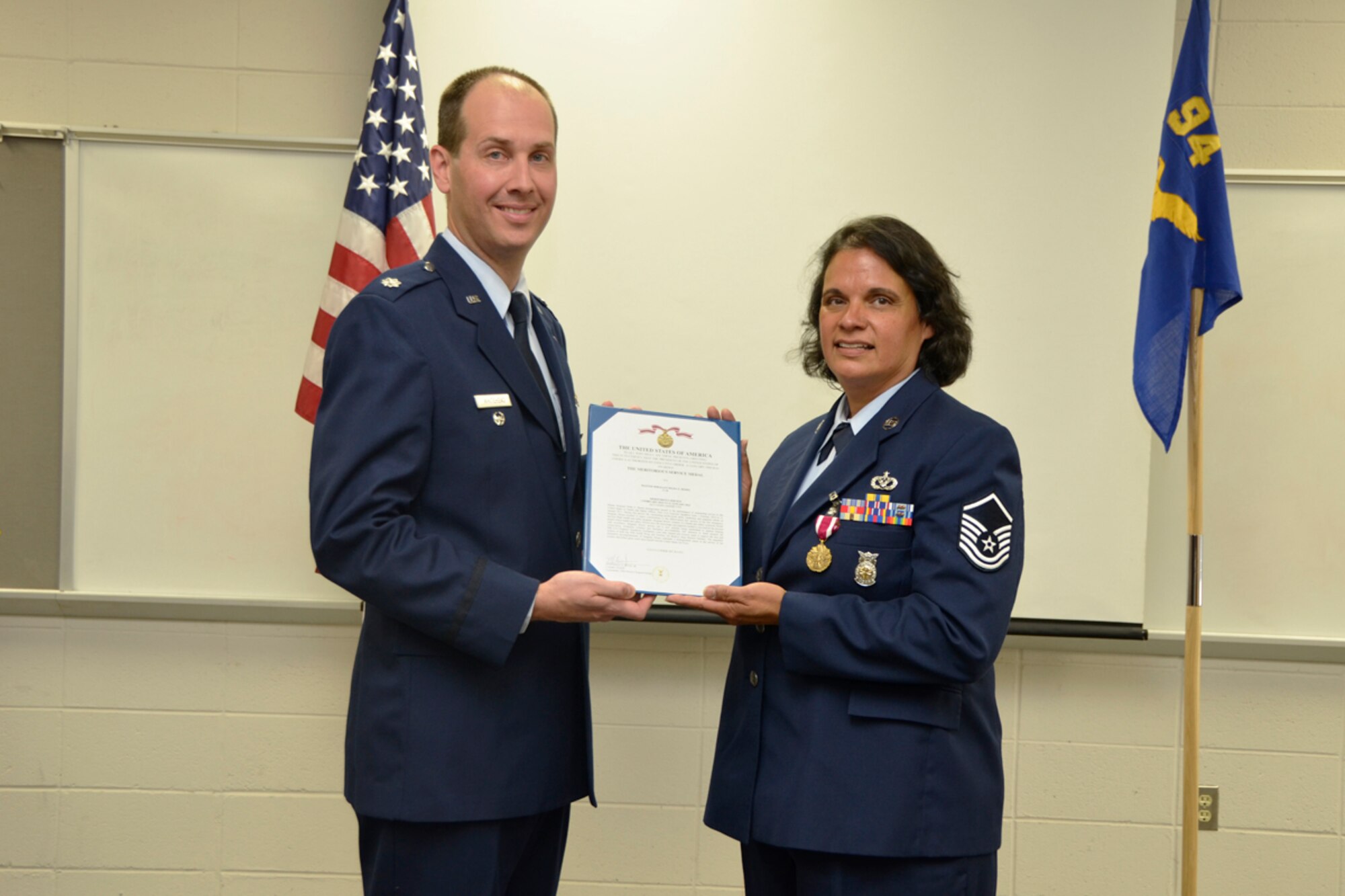 Lt. Col. Christopher Whitehead, 94th Mission Support Group deputy commander and former 94th CES commander, presents Master Sgt. Hilda Elaine Moses, 94th Civil Engineer Squadron health and safety officer, during her retirement ceremony, April 14. Moses celebrated 23 years of dedicated service to the U.S. Air Force. (U.S. Air Force photo/Master Sgt. James Branch)