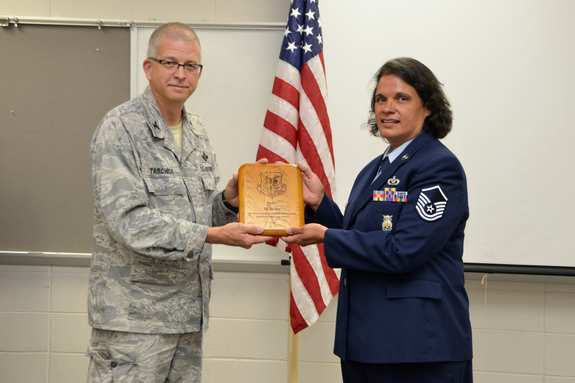 Col. Tim Tarchick, 94th Airlift Wing commander, presents Master Sgt. Hilda Elaine Moses, 94th Civil Engineer Squadron health and safety officer, with a token of appreciation during her retirement ceremony, April 14. Moses celebrated 23 years of dedicated service to the U.S. Air Force. “Looking back at Moses’ career, she can be summed up in one word… tough,” said Tarchick. (U.S. Air Force photo/Master Sgt. James Branch)