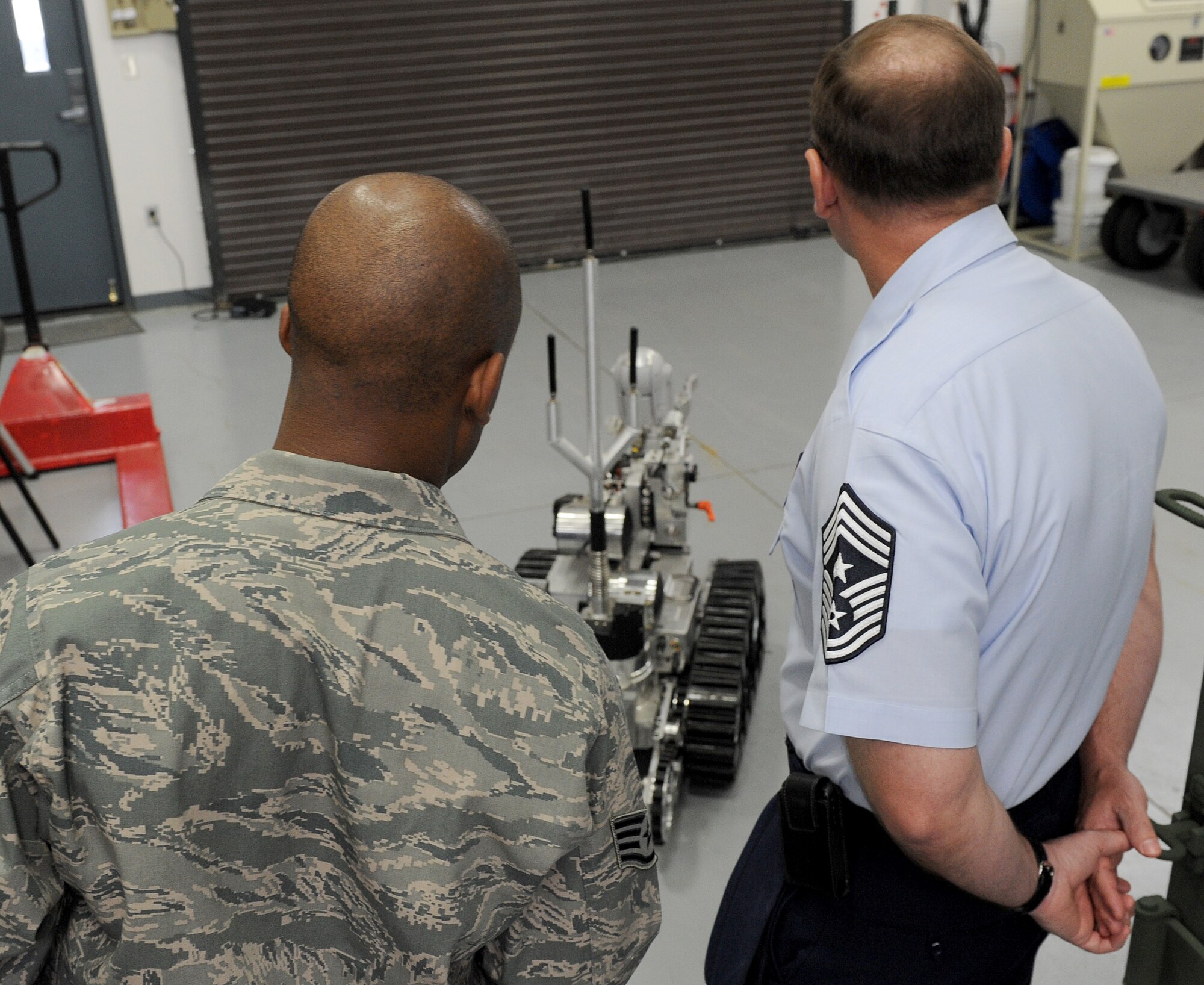 Staff Sgt Brandon Chism, 375th Civil Engineer Squadron explosive ordinance disposal, shows Chief Marty Anderson, 375th Air Mobility Wing command chief, how to operate the EOD robot April 16 at Scott Air Force Base, Ill.  The average cost per robot is over $100,000. (U.S. Air Force photo/Airman 1st Class Divine Cox)