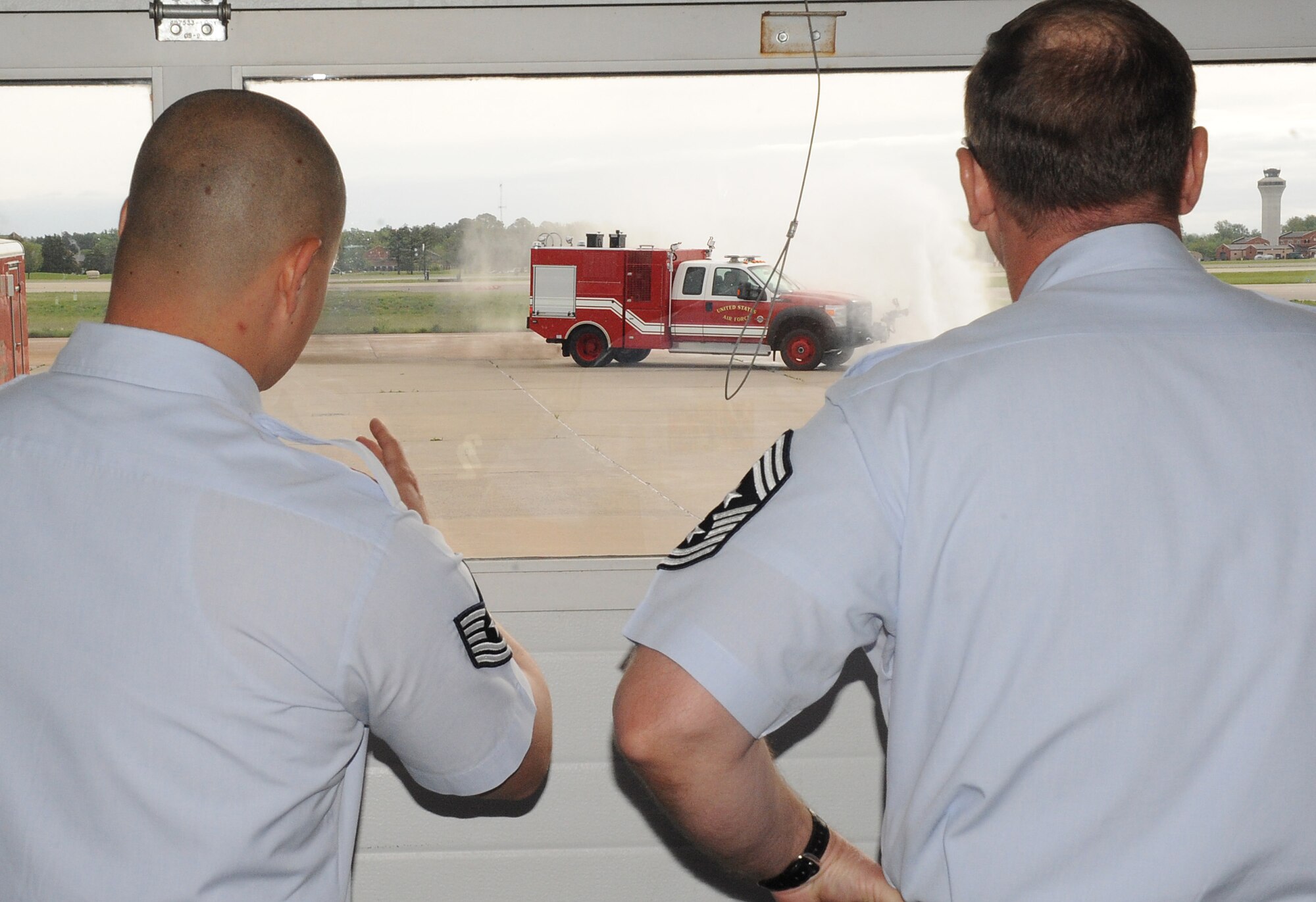 Chief Marty Anderson, 375th Air Mobility Wing command chief and Tech Sgt. Lincoln Ratliff, 375th Civil Engineer Squadron fire fighter, looks at a water demonstration from one of the fire trucks April 16, 2012 at Scott Air Force Base, Ill.  Chief Anderson visited different squadrons throughout the base to gather information on how that specific squadron's mission affects the base. (U.S. Air Force photo/Airman 1st Class Divine Cox)