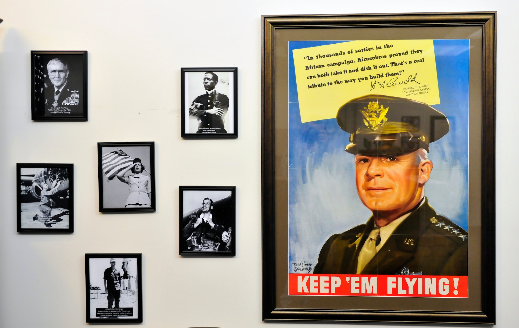 An original 1942 Hap Arnold poster hangs in the lobby of the 28th Operational Weather Squadron along with other historical Air Force photos, Shaw Air Force Base, S.C., April 6, 2012. Volunteers from the 28th OWS created an Air Force memorabilia display in their lobby to help squadron members and visitors gain a sense of pride in their heritage. (U.S. Air Force photo by Senior Airman Daniel Phelps/Released)