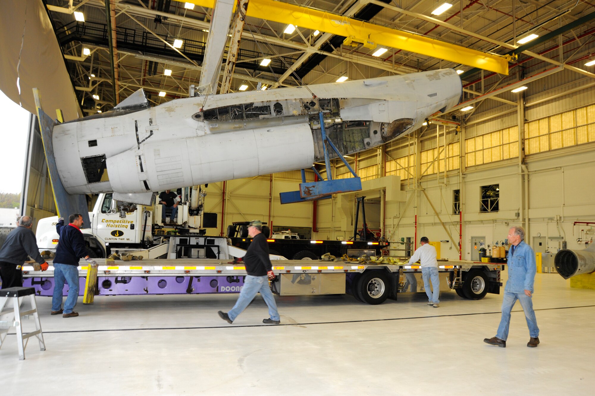 Volunteers from the Selfridge Military Air Museum watch as a crane lifts the fuselage of an F-89 Scorpion off a flatbed truck into an aircraft hangar at Selfridge Air National Guard Base, Mich., April 16, 2012. Once finished, museum officials believe they will have the only restored F-89 “C” model on display in the country, possibly the world. (U.S. Air Force photo by SSgt. Rachel Barton)