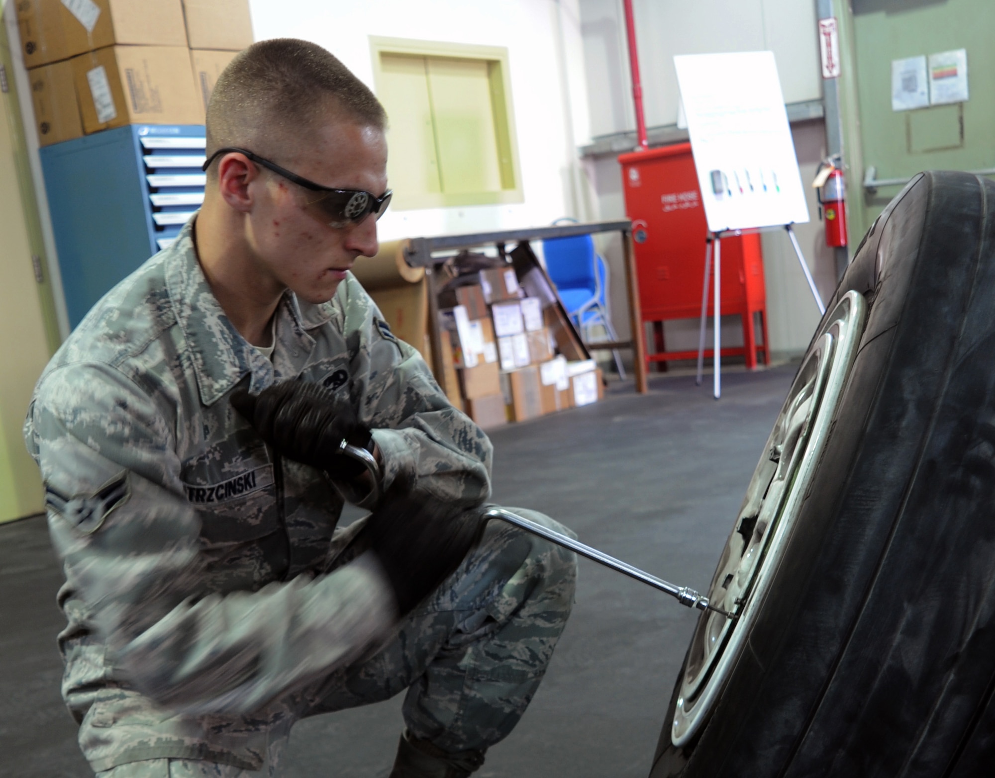 SOUTHWEST ASIA - Airman 1st Class Paul Trzcinski disassembles an F-15 Eagle wheel April 10, 2012. He's deployed to the 380th Air Expeditionary Wing as part of a team of six Airmen at the new wheel and tire shop here. (U.S. Air Force photo/Staff Sgt. J.G. Buzanowski)