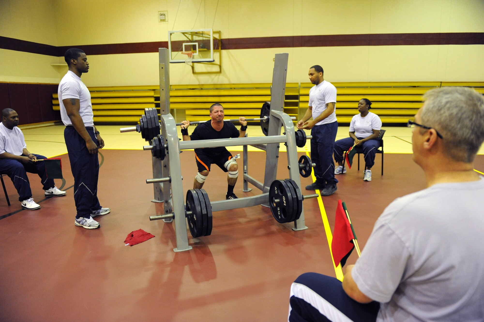 Adam Plummer, center, squats 355 pounds while members of the fitness center staff watch for proper form during a powerlifting competition April 14, 2012, at Incirlik Air Base, Turkey. Plummer took third place overall in the competition, which is his first powerlifting competition. (U.S. Air Force photo by Senior Airman Anthony Sanchelli/Released)
