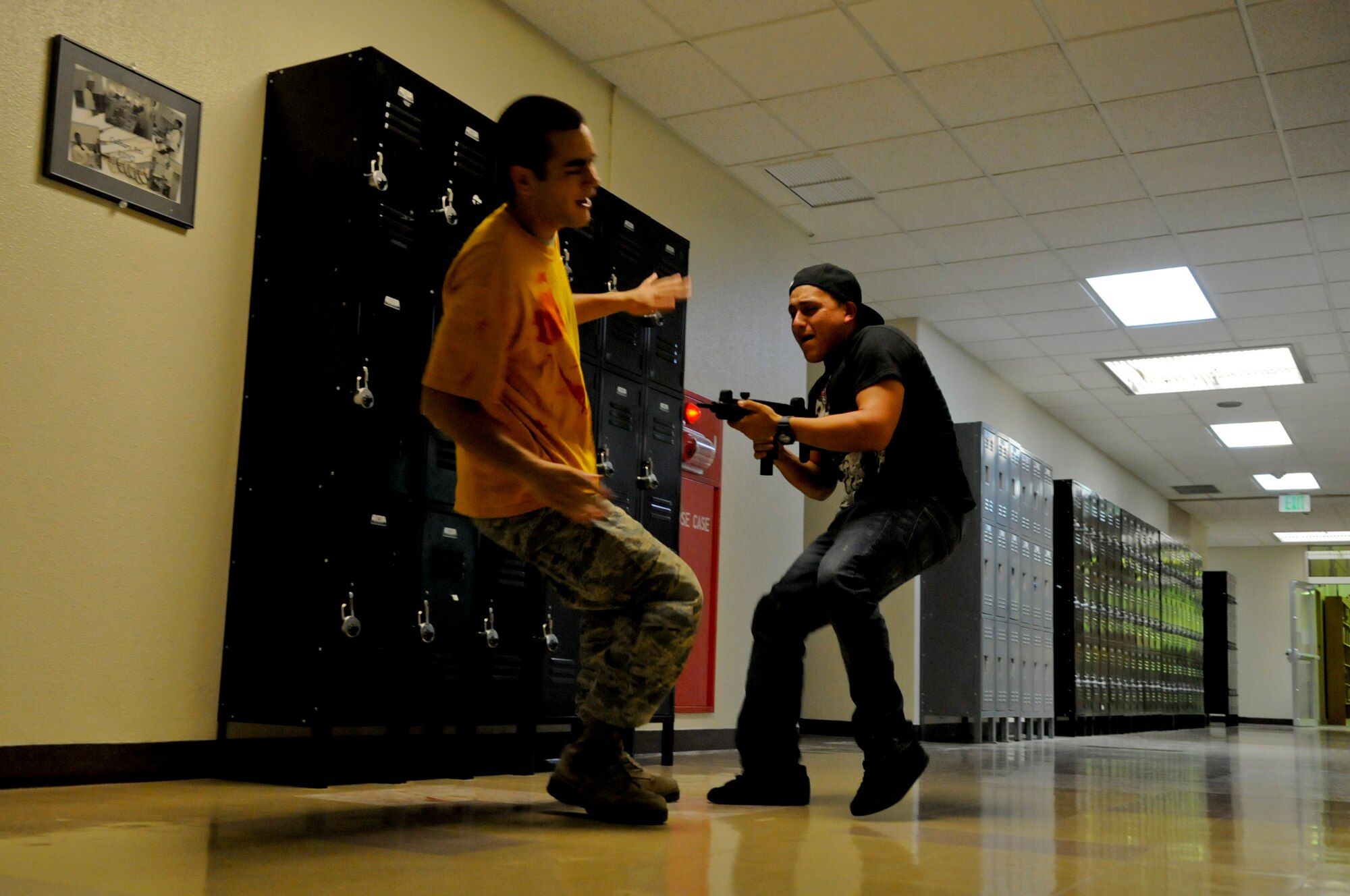 An "active shooter" encounters a helpless victim during a High Risk Response course on Kadena Air Base, Japan, April 12, 2012. Kadena members throughout the base volunteered as victims to give realism and urgency to the scenarios played out during the day's training. (U.S. Air Force photo by Airman 1st Class Tara A. Williamson/Released)