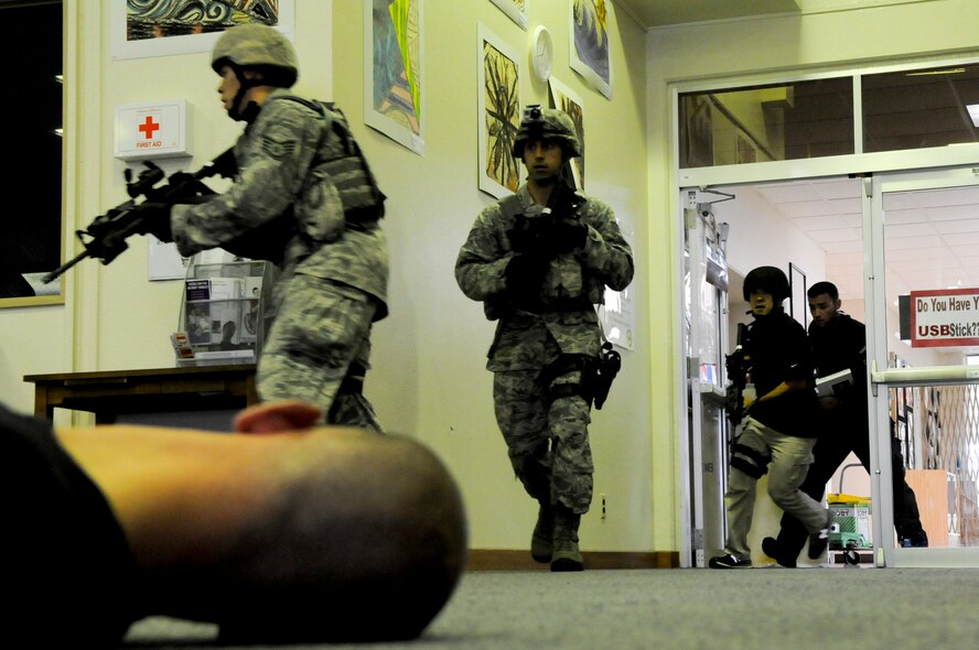 A team of responders move through the library of Kadena High School during an active-shooter scenario in a High Risk Response train-the-trainer course on Kadena Air Base, Japan, April 12, 2012. During this five-day course, participants are taught to swiftly eliminate active shooters and other high-risk threats. (U.S. Air Force photo by Airman 1st Class Tara A. Williamson/Released)
