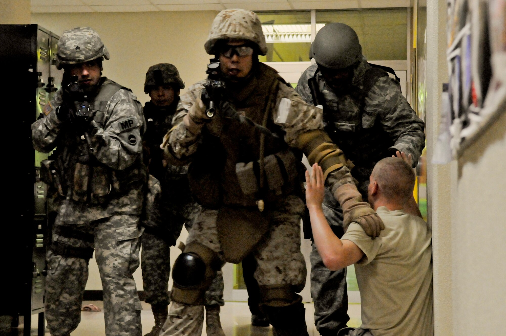 Members from the U.S. Marine Corps, U.S. Army and U.S. Air Force come across a role player during an active-shooter scenario on Kadena Air Base, Japan, April 12, 2012. Members from each U.S. military branch, along with their civilian counterparts, participated in a five-day train-the-trainer program which allows those taking the course to bring their new skills back to their units. (U.S. Air Force photo by Airman 1st Class Tara A. Williamson/Released)