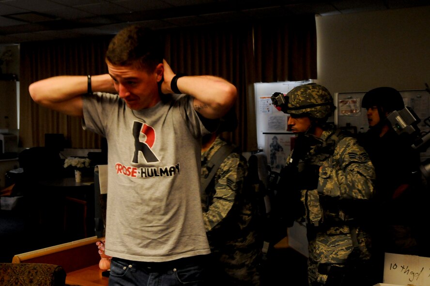 U.S. Air Force Airman 1st Class Adrian Durr, 18th Security Forces Squadron Response Force member, is escorted out of a room by fellow 18th SFS members during a Pacific Air Forces High Risk Response Training active-shooter scenario on Kadena Air Base, Japan, April 12, 2012. Kadena members from different sections of the base volunteered as victims to give realism and urgency to the scenarios played out during the day's training. (U.S. Air Force photo by Airman 1st Class Tara A. Williamson/Released)