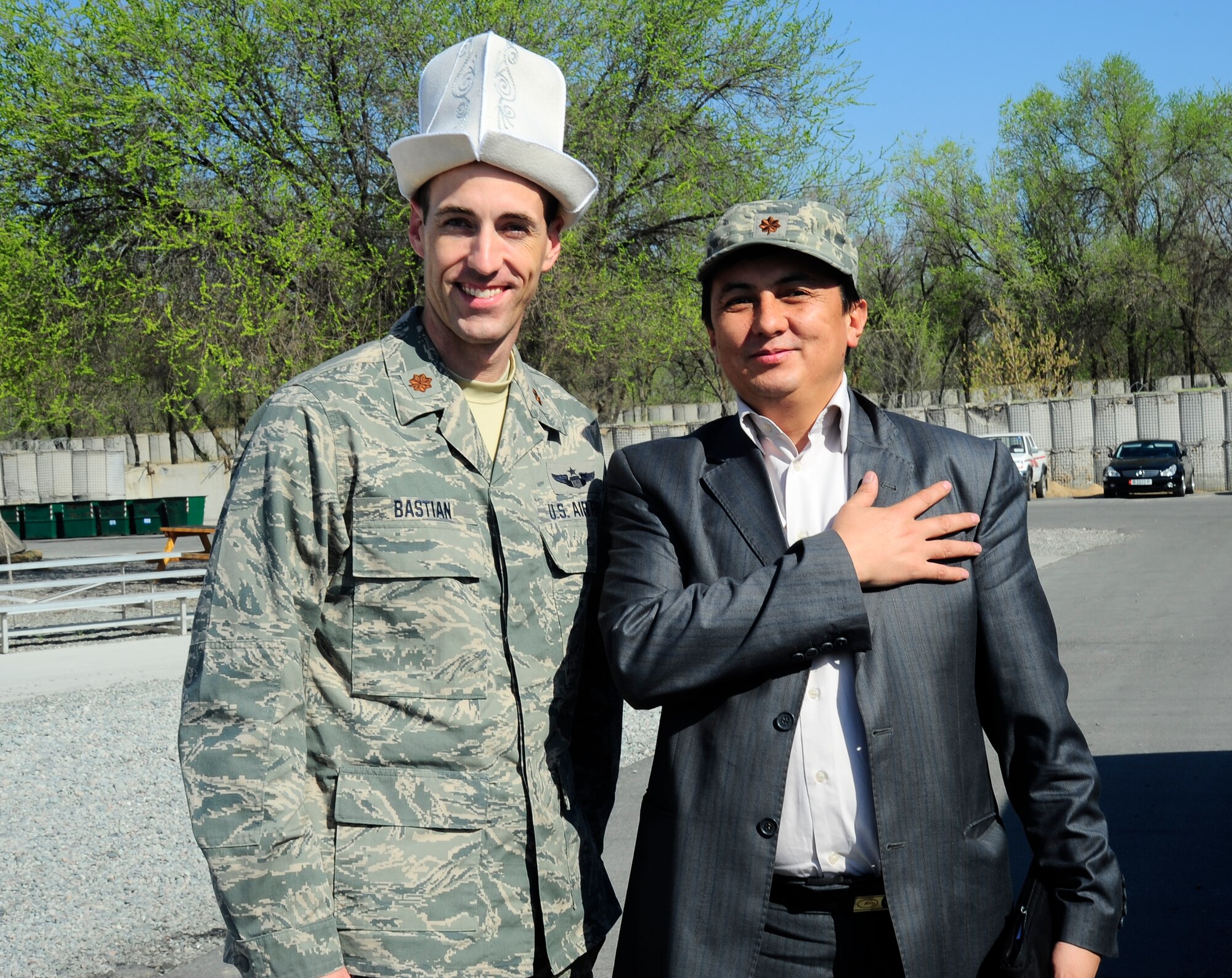 Maj. Russell Bastian trades hats with Kubatbek Chekirov April 12, 2012, at the Transit Center at Manas, Kyrgyzstan, during a Kyrgyz Republic Ministry of Education and Science visit to the Transit Center. Bastian is the 376th Air Expeditionary Wing Theater Security Cooperation division director and is deployed here from Randolph Air Force Base, Texas. Chekirov is a local reporter. (U.S. Air Force photo/Staff Sgt. Angela Ruiz)