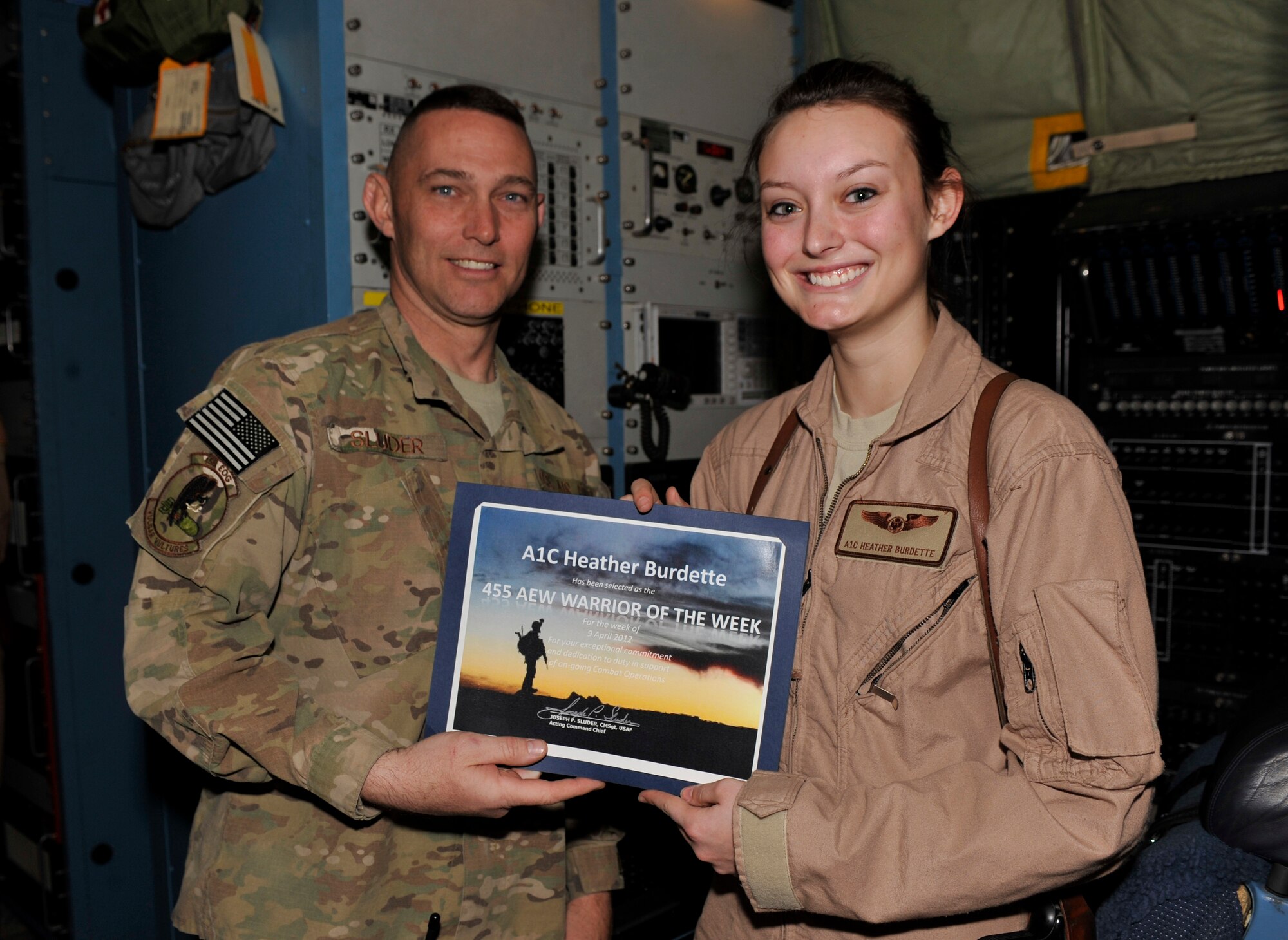 Airman 1st Class Heather Burdette receives the Warrior of the Week award from Chief Master Sgt. Joseph Sluder at Bagram Airfield, Afghanistan, April 16, 2012. Sluder is the 455th Expeditionary Operations Group chief enlisted manager and Burdette is an EC-130H airborne maintenance technician with the 41st Expeditionary Electronic Combat Squadron. She earned the Warrior of the Week award for her hard work and dedication to excellence. (U.S. Air Force photo/ Airman 1st Class Ericka Engblom)