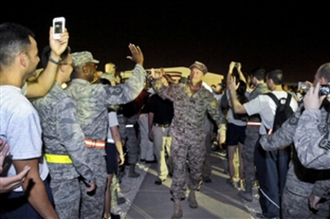 U.S. Navy Adm. James A. Winnefeld Jr., vice chairman of the Joint Chiefs of Staff, leads a team of celebrities with a USO spring tour through a corridor of fans to a stage in Southwest Asia, April 17, 2012. Several thousand U.S. troops and coalition partners listened as celebrities spoke, sang and took photos with fans.