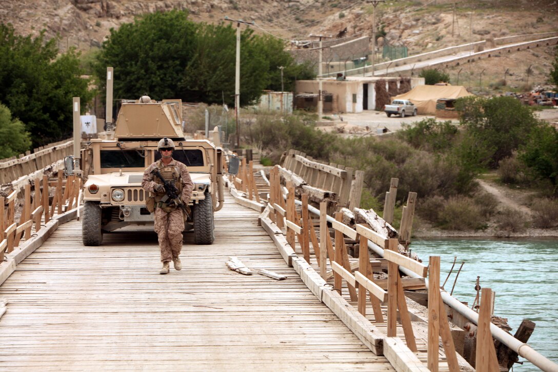 A Marine serving with Alpha Company, 1st Battalion, 8th Marine Regiment, guides a vehicle across a bridge crossing the Helmand River here, April 20, 2012. The Marines resupplied Observation Post Shrine, the northernmost Marine position in Kajaki. (U.S. Marine Corps photo by Lance Cpl. Tyler Reiriz)