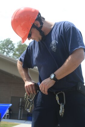 Air Station firefighter and paramedic Jody Avant removes his equipment after taking part in the training exercise April 18 at the Structural Fire Department.The course consisted of small spaces and various obstacles that firefighters had to maneuver through.