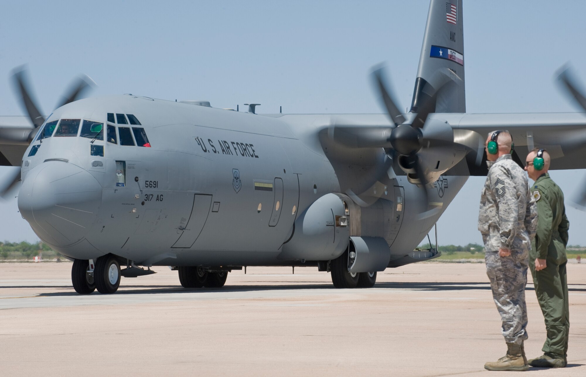 Dyess leadership stands at attention as a new C-130J is taxies in April 18, 2012, at Dyess Air Force Base, Texas. The aircraft is the 18th of 28 to be delivered to Dyess, replacing the legacy fleet of the C-130 Hercules model. (U.S. Air Force photo by Airman 1st Class Jonathan Stefanko/ Released)