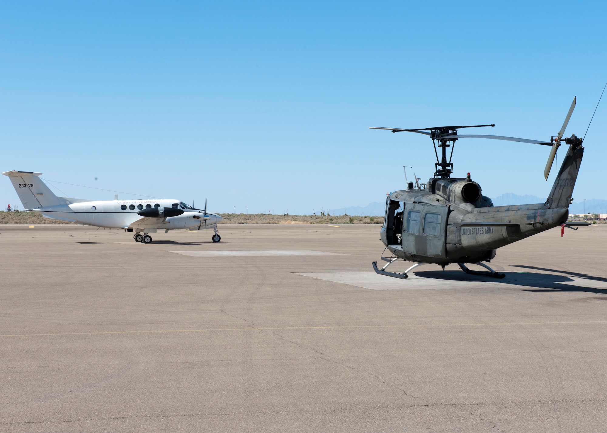 HOLLOMAN AIR FORCE BASE, N.M. – A UH-1 Iroquois and C-12 Huron from the U.S. Army Air Operations Directive sit along the flight line before a training flight April 12. The Army Air Operations Directive flies out of Holloman AFB on training missions. The pilots of Army Air Operations Directive are all civilians who have extensive military background. (U.S. Air Force photo by Senior Airman DeAndre Curtiss/Released)