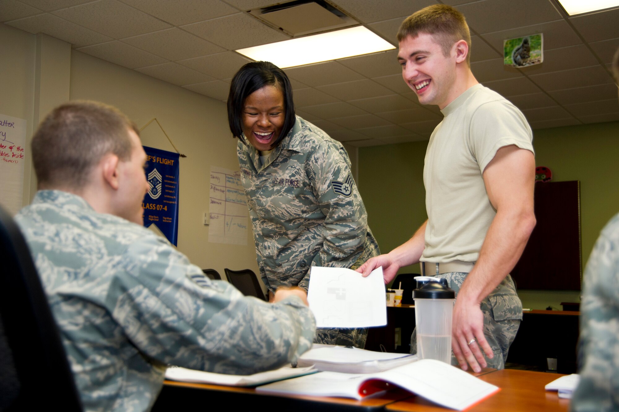 Tech. Sgt. Adrienne Russell-George, center, 81st Force Support Squadron, reacts as Senior Airmen Alex Hand and Benjamin Byers, 85th Engineering Installation Squadron, show George their image they created during a communications exercise while attending Airman Leadership School April 11, 2012 at Keesler Air Force Base, Miss.  Hand, left, had to draw a shape provided by Byers who gave oral instructions on how to draw the shape.  (U.S. Air Force photo by Adam Bond)