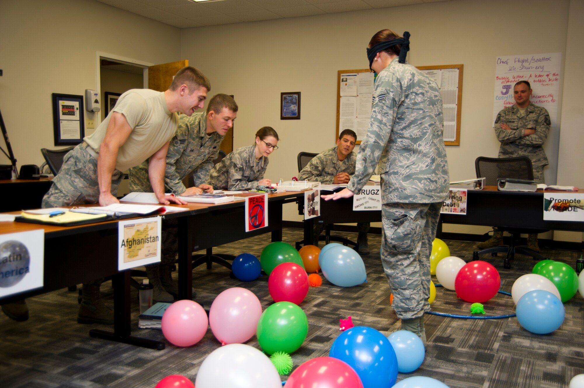 Senior Airman Benjamin Byers, 85th Engineering Installation Squadron, far left, guides a blindfolded Senior Airman Emily Zanes, 81st Medical Support Squadron, through a balloon “minefield” April 11, 2012, at Keesler Air Force Base, Miss. The activity is part of a series of Airman Leadership School exercises to enhance communication skills.  (U.S. Air Force photo by Adam Bond)