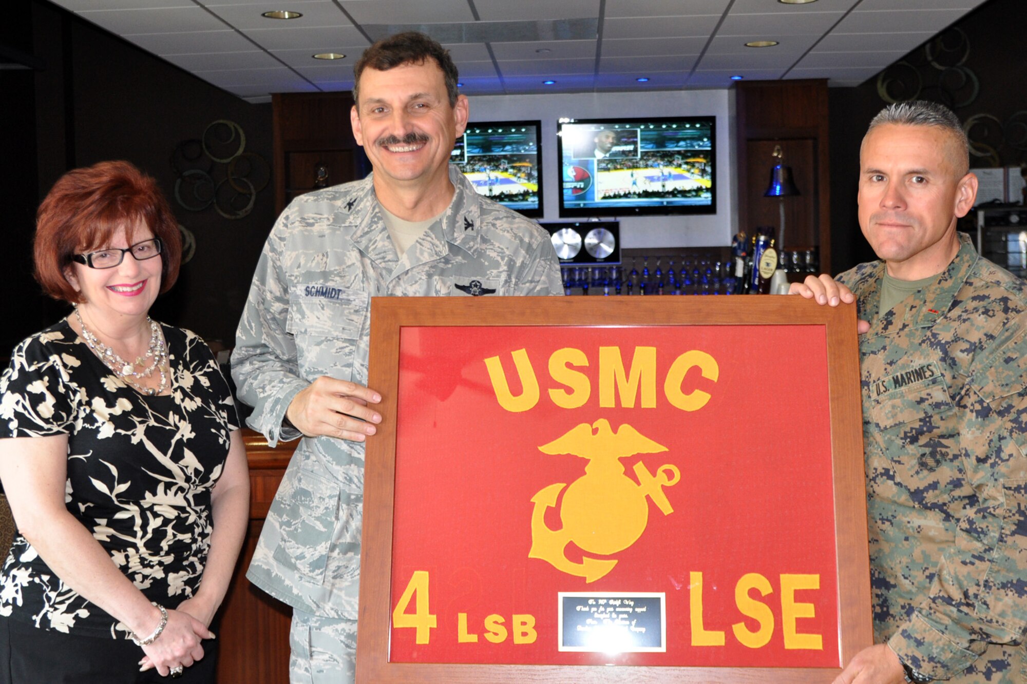 YOUNGSTOWN AIR RESERVE STATION, Ohio – Air Force Reserve Col. Reinhard Schmidt, 910th Airlift Wing commander, receives a framed unit flag from Chief Warrant Officer Emiliano DeLeon, Marine Corps Reserve Landing Support Equipment Company (MCRLSEC) Inspector/Instructor, at the Community Activity Center here, April 15, 2012. The MCRLSEC is a tenant unit at the air station and presented the framed flag to the 910th, their host unit, to thank them for “unwavering support throughout the years.” U.S. Air Force photo by Master Sgt. Bob Barko Jr.