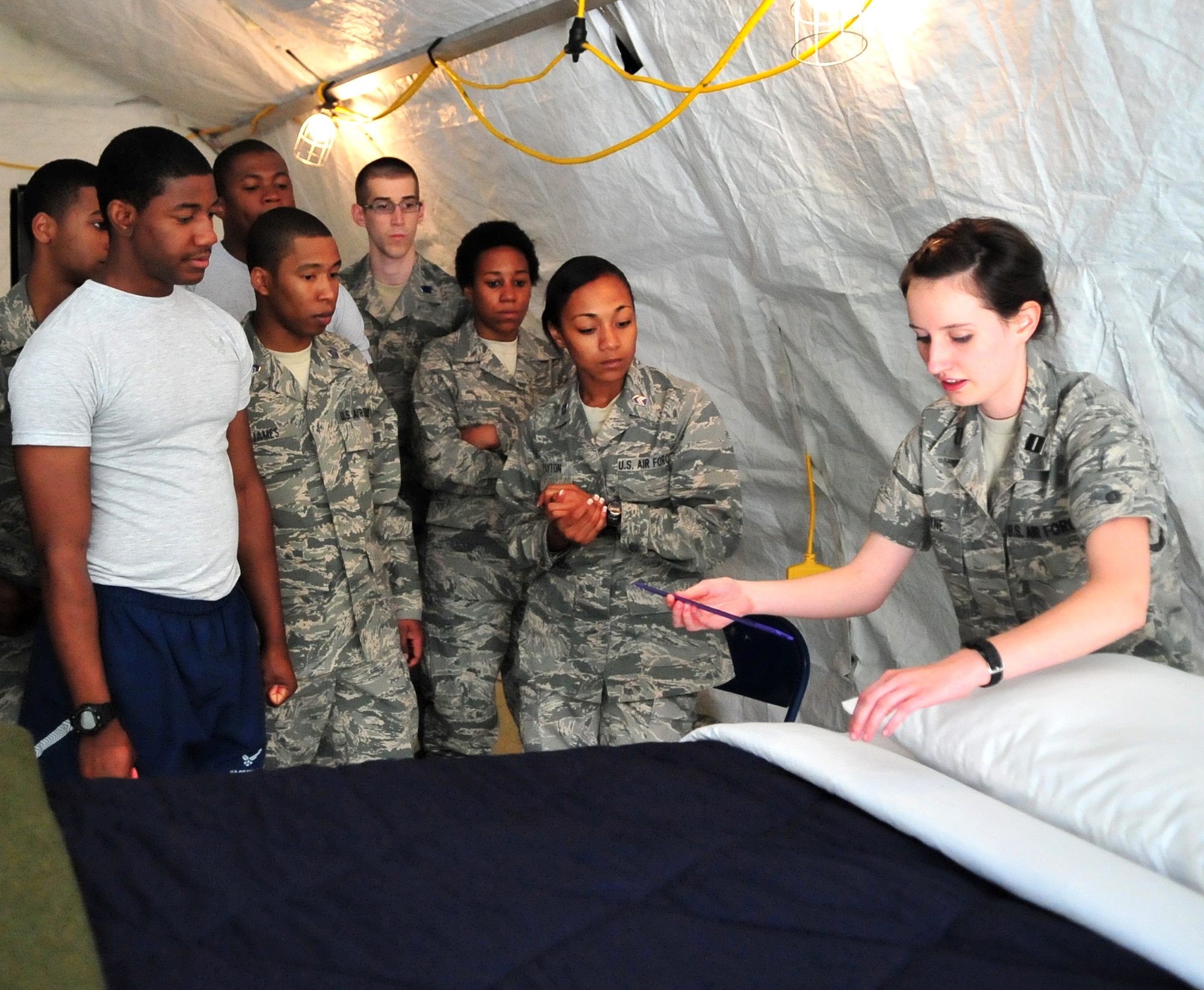 Air Force ROTC Cadet Rachael Layne instructs fellow cadets on how to make a regulation military-style "dust cover" bed on Seymour Johnson Air Force Base, N.C., April 14, 2012. A total of 81 cadets from seven colleges throughout North Carolina gathered here to prepare for a mandatory 28-day field training course held at Maxwell Air Force Base, Ala. Layne, student at University of North Carolina Charlotte, is from Vancouver, Wash. (U.S. Air Force photo/Staff Sgt. Makenzie Lang/Released)