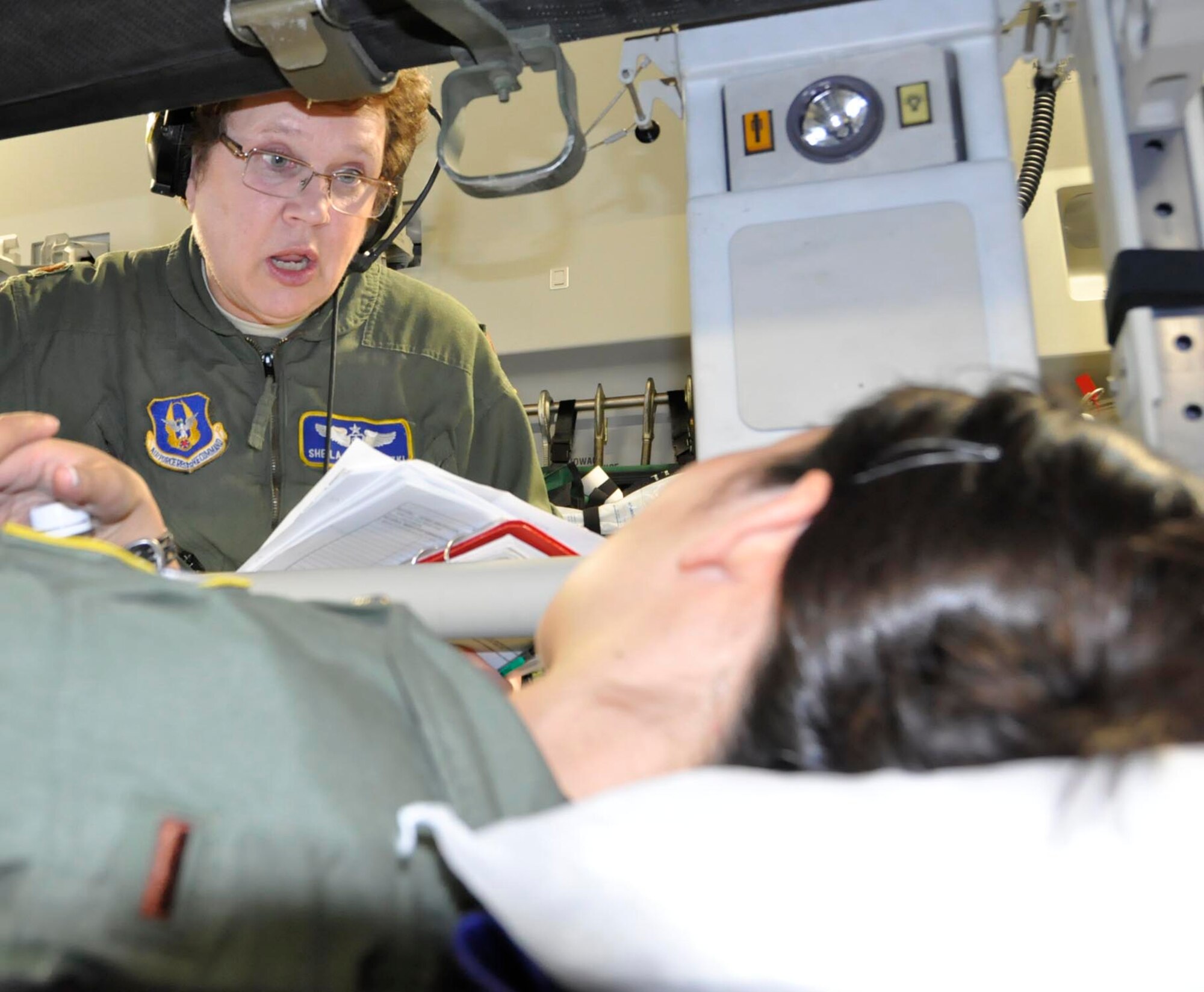 Maj. Sheila Wojewodzki, a flight nurse with the 446th Aeromedical Evacuation Squadron, consoles a simulated patient during a medical exercise aboard one of McChord Field's C-17's. AES Reservists performed the training during a humanitarian mission from Youngstown Air Reserve Station, Ohio to San Salvador, El Salvador. Aeromedical team members must fly, at a minimum, every 90 days in a crew position to maintain their current skill status. (U.S. Air Force photo/Staff Sgt. Rachael Garneau)