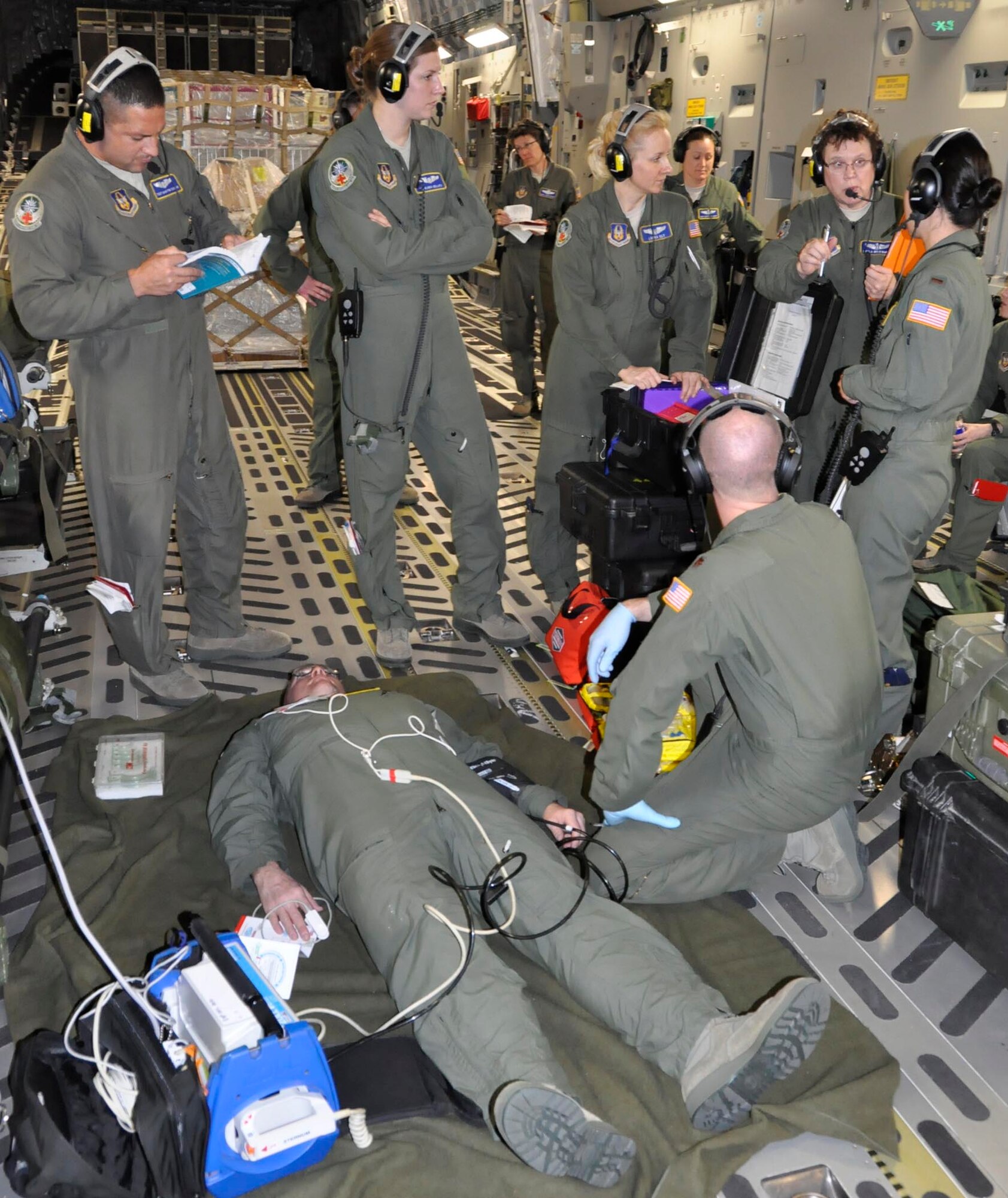 Maj. Sheila Wojewodzki, second from the right, instructs a group of 446th Aeromedical Evacuation Squadron Reservists on in-flight medical operations during a simulated emergency aboard one of McChord Field's C-17's. Wojewodzki is a flight nurse with the AES. The aeromedical team members performed the training during a humanitarian mission from Youngstown Air Reserve Station, Ohio to San Salvador, El Salvador. (U.S. Air Force photo/Staff Sgt. Rachael Garneau)