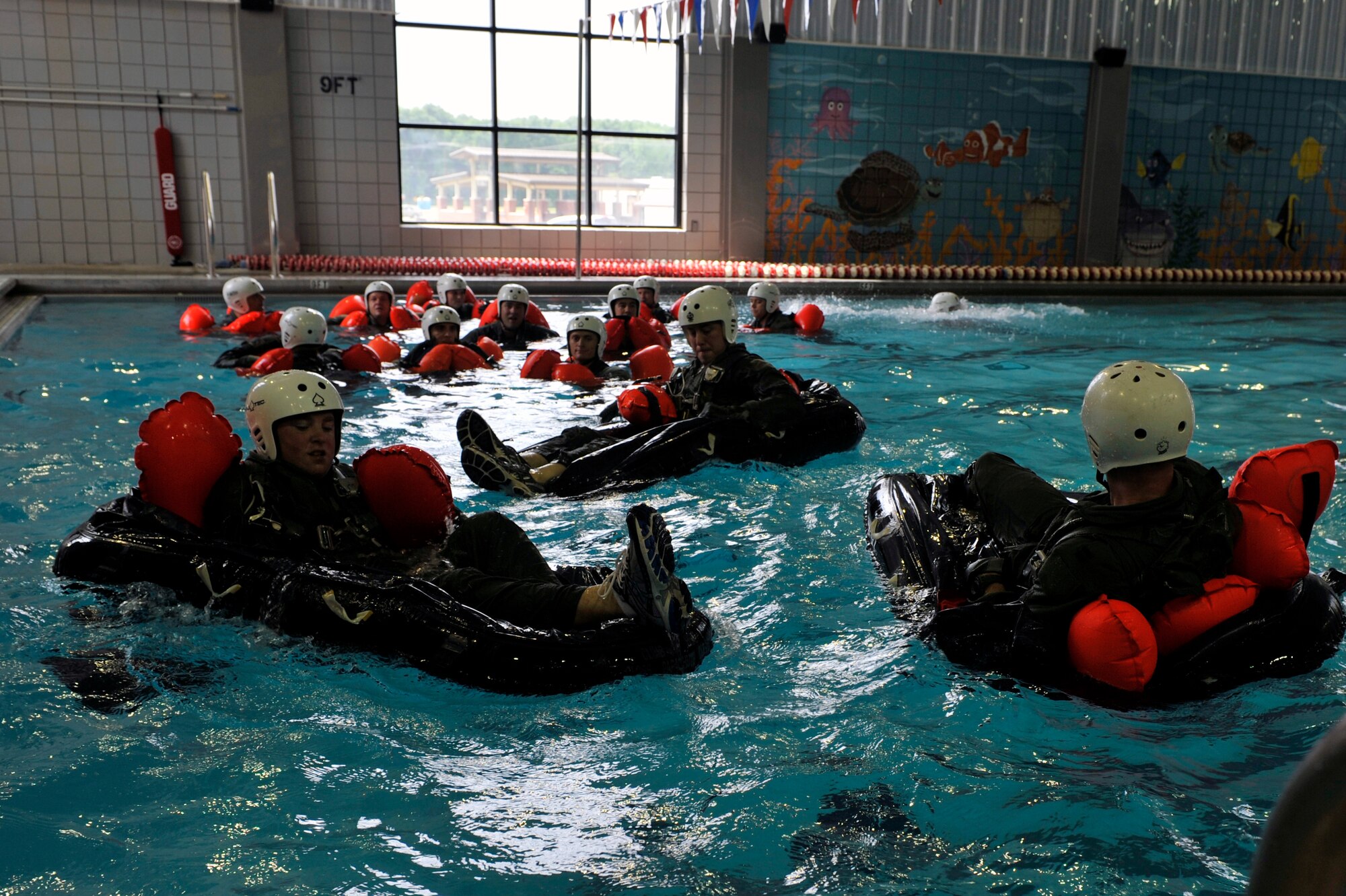 Team Little Rock members participate in water survival training, April 13, 2012, inside the Jacksonville Community Center, at Jacksonville, Ark. During the water survival training, Team Little Rock members learned how to escape a canopy, disconnect a parachute during high winds, and various other techniques. (U.S. Air Force photo by Airman 1st Class Rusty Frank)