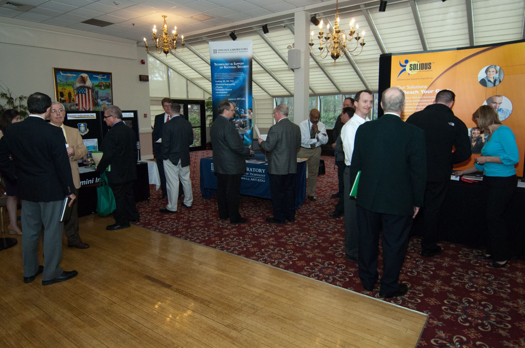 HANSCOM AIR FORCE BASE, Mass. – Attendees talk to business representatives about the opportunities offered at the many industries in attendance during a career fair held at the Minuteman Commons April 12. Thirteen companies attended the fair to distribute information about career opportunities and to accept resumes. This event was sponsored by Transition Careers. (U.S. Air Force photo by Rick Berry)