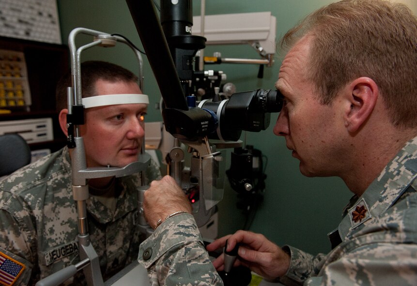 Maj. Bryan Kemper, 28th Medical Operations Squadron optometrist, performs a slit lamp test on U.S.  Staff Sgt. David Neugebauer, 235th Military Police Company training NCO, during a routine eye exam in the optometry clinic at Ellsworth Air Force Base, S.D., April 12, 2012. The test consists of visually evaluating the surface of eyes for anything that could harm the eye or its vision. (U.S. Air Force photo by Airman 1st Class Kate Thornton/Released)