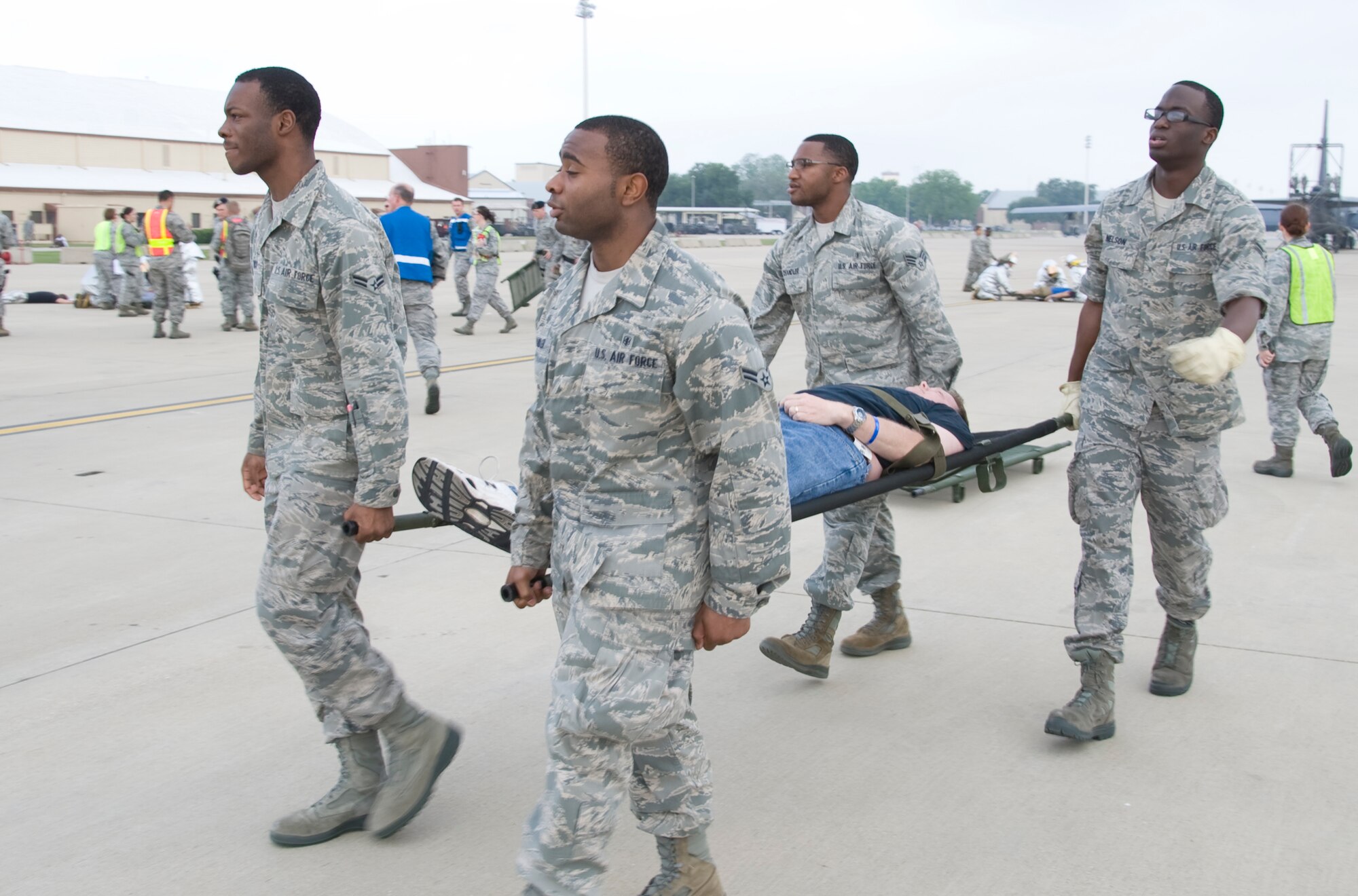 Members of Team Barksdale litter-carry a simulated casualty during a Major Accident Response Exercise on Barksdale Air Force Base, La., April 13. The 2nd Bomb Wing holds an annual MARE before every air show to evaluate how base units and community emergency services agencies would respond to an incident. (U.S. Air Force photo illustration/Airman 1st Class Benjamin Gonsier)(RELEASED)

