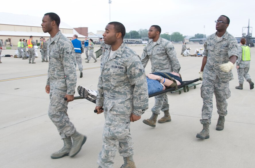 Members of Team Barksdale litter-carry a simulated casualty during a Major Accident Response Exercise on Barksdale Air Force Base, La., April 13. The 2nd Bomb Wing holds an annual MARE before every air show to evaluate how base units and community emergency services agencies would respond to an incident. (U.S. Air Force photo illustration/Airman 1st Class Benjamin Gonsier)(RELEASED)

