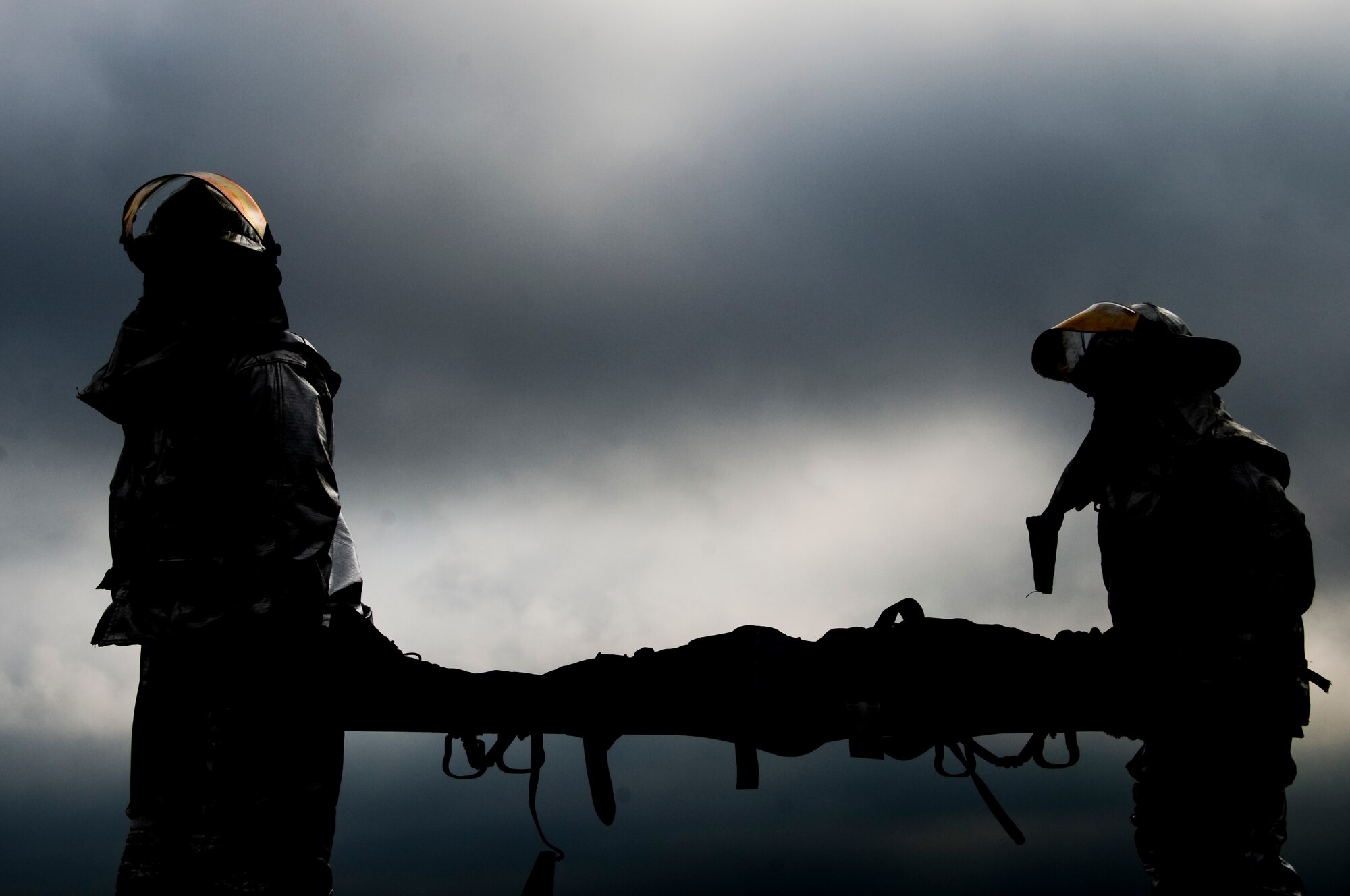 Members of Team Barksdale litter-carry a simulated casualty during a Major Accident Response Exercise on Barksdale Air Force Base, La., April 13. The 2nd Bomb Wing holds an annual MARE before every air show to evaluate how base units and community emergency services agencies would respond to an incident. (U.S. Air Force photo illustration/Airman 1st Class Benjamin Gonsier)(RELEASED)
