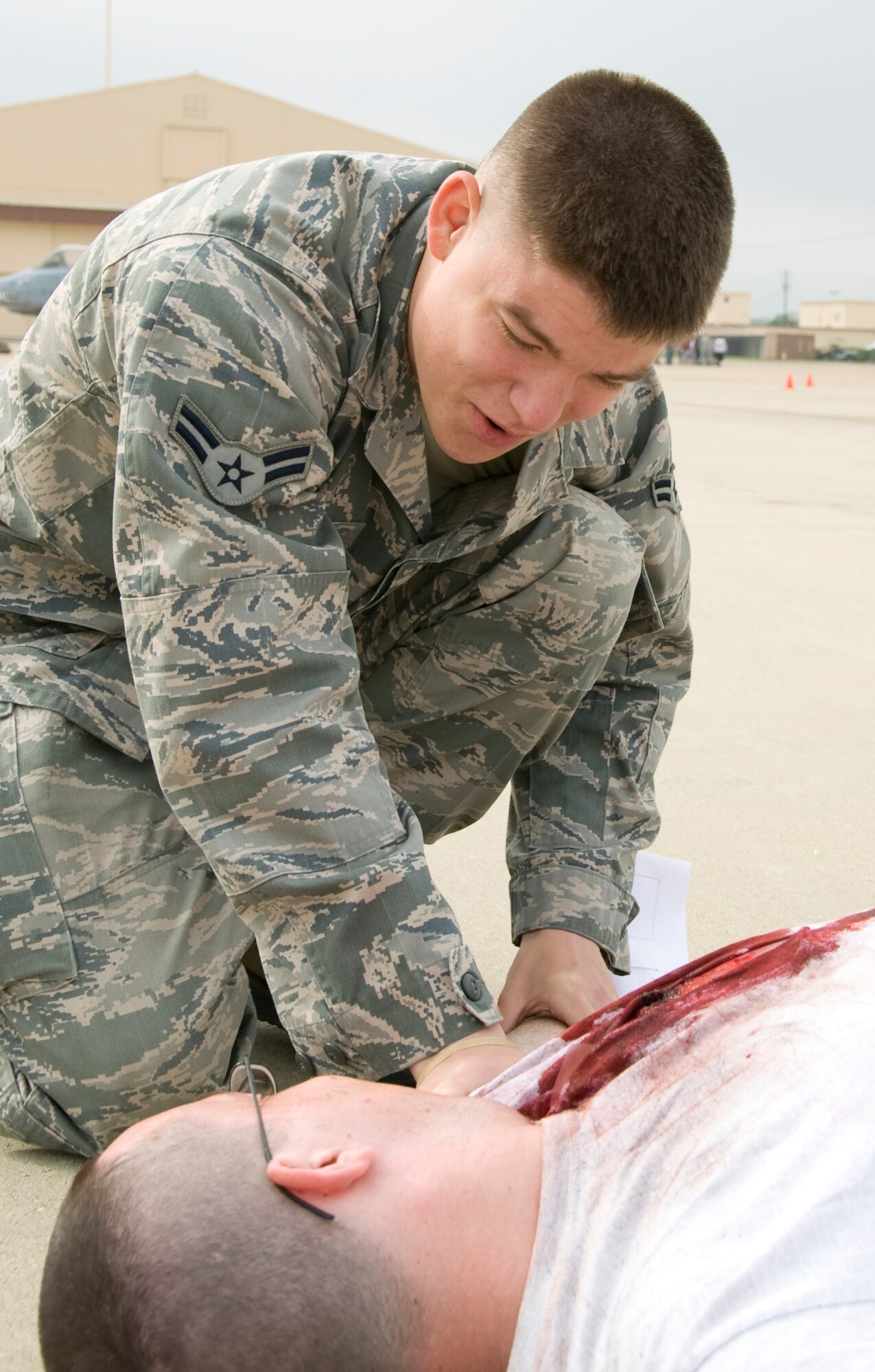 A Barksdale Airman applies self-aid buddy care techniques to an Airman with simulated injuries on Barksdale Air Force Base, La., April 13. The 2nd Bomb Wing held a Major Accident Response Exercise to prepare base personnel and community emergency services responders in case of an accident during the Barksdale air show April 21-22. (U.S. Air Force photo/Airman 1st Class Benjamin Gonsier)(RELEASED)
