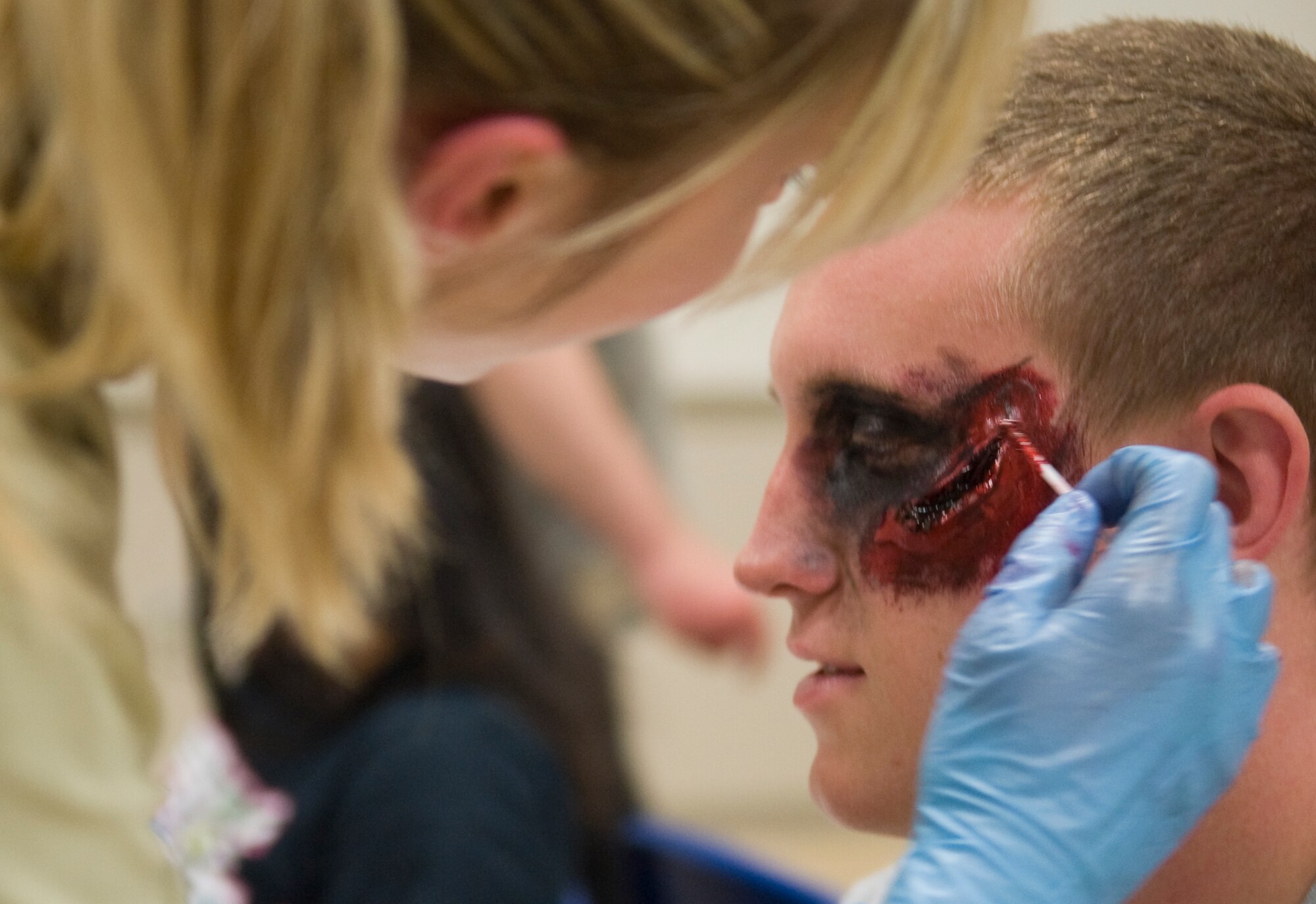 Members of the 2nd Medical Group apply make-up on Airmen volunteering to be moulaged casualties for a Major Accident Response Exercise on Barksdale Air Force Base, La., April 13. More than 100 Team Barksdale members volunteered to be simulated protestors and moulaged casualties for the MARE. (U.S. Air Force photo/Airman 1st Class Benjamin Gonsier)(RELEASED)
