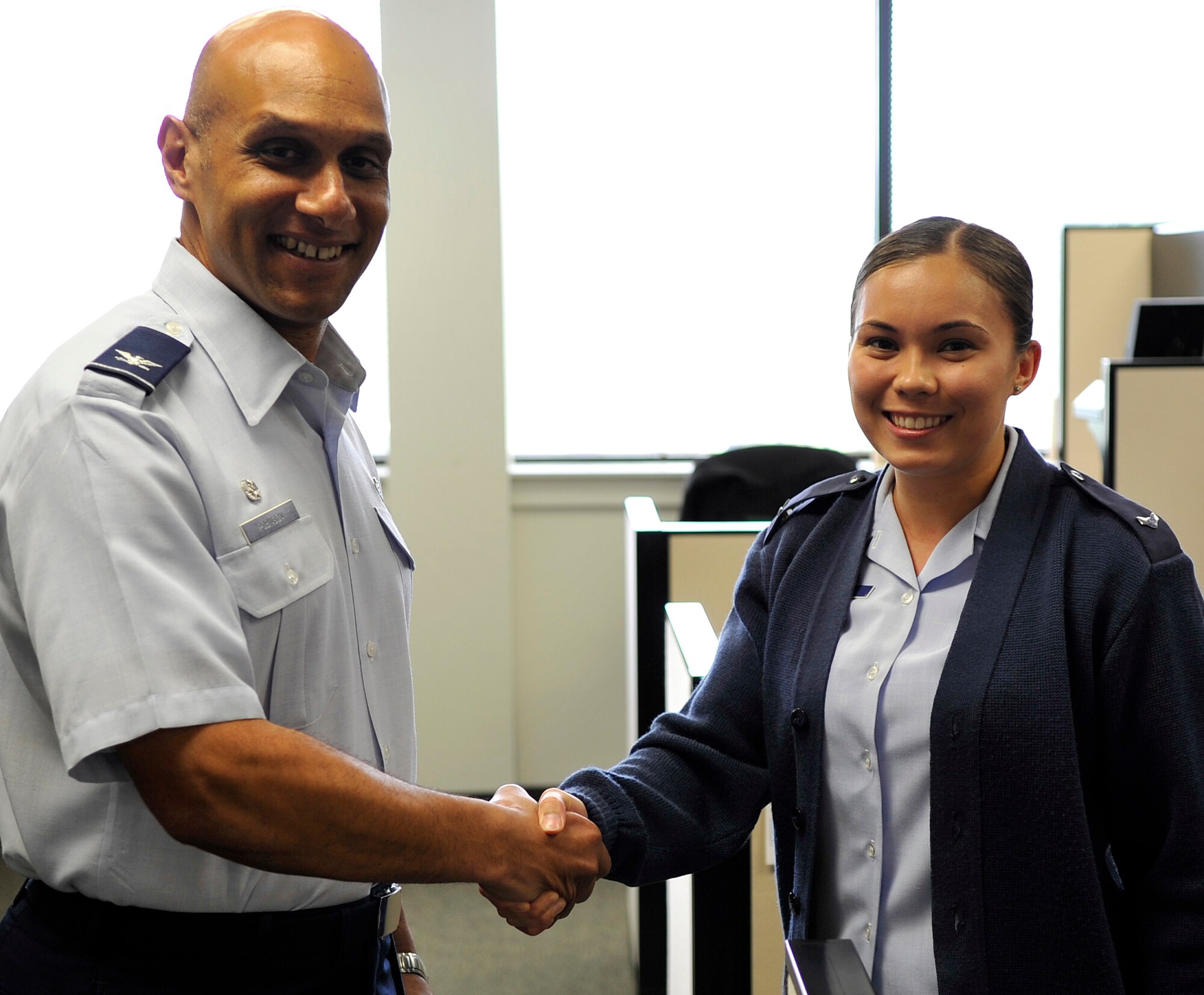 Col. Brian Robinson, 19th Airlift Wing commander, presents a commander's coin to Airman 1st Class Keren Williams, a 19th Comptroller Squadron financial analyst, April 16, 2012, at Little Rock Air Force Base, Ark. Williams was recognized for successfully tracking outstanding travel orders and saving money for the wing. (U.S. Air Force photo by Senior Airman Caleb Pierce)