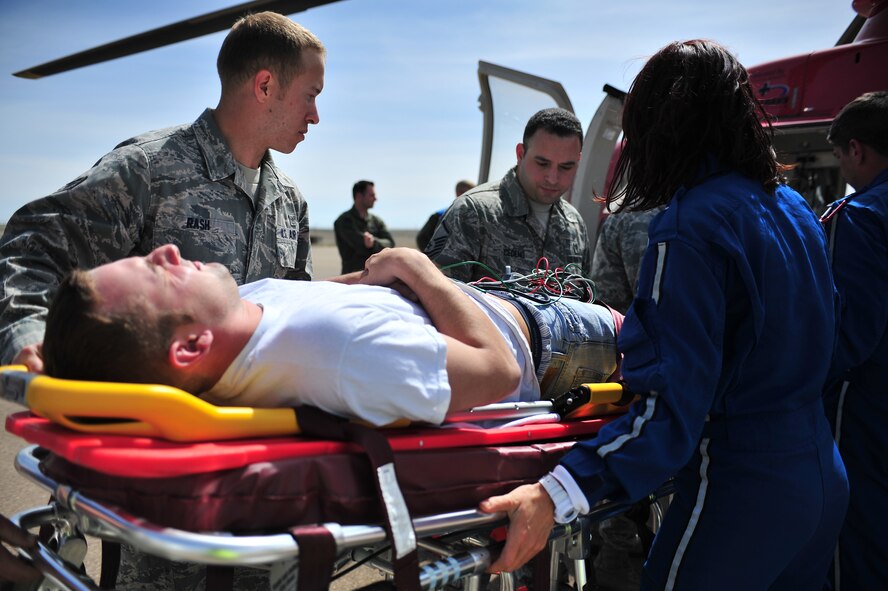 Cannon Air Commandos and life flight helicopter crew members load a simulated tornado victim onboard during natural disaster exercise at Cannon Air Force Base, N.M., April 5, 2012. Training exercises provide a safe and controlled environment to practice tactics, techniques and procedures.(U.S. Air Force photo by Airman 1st Class Alexxis Pons Abascal)