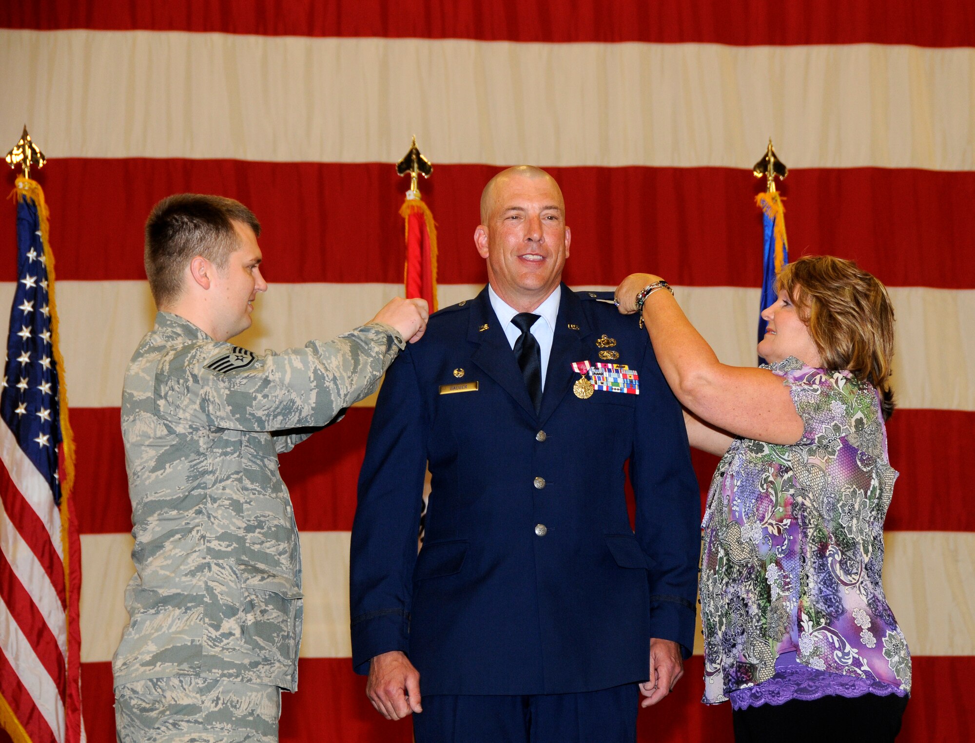 Staff Sgt. Andy Dodd, 188th Fighter Wing Maintenance Group, left, and Sherri Gauger, pin on the rank of colonel on Col. Pete Gauger, 188th Fighter Wing vice commander April 14, 2012. Gauger, the former Mission Support Group commander, was promoted to colonel and elevated to the position of 188th Fighter Wing vice commander during a formal 188th MSG change-of-command ceremony. (National Guard photo by Senior Master Sgt. Dennis Brambl/188th Fighter Wing Public Affairs)