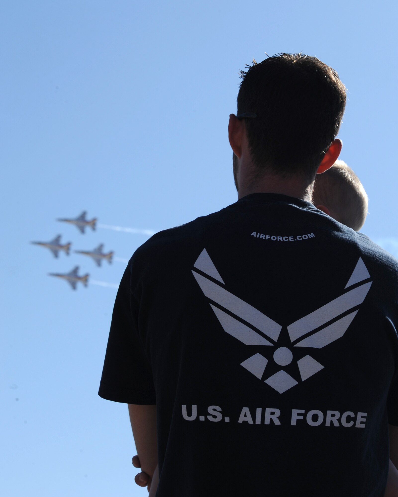 Dackory Dowdle, a military spouse, holds his son, Easton, as they watch the U.S. Air Force Thunderbird demonstration team’s formation during the 2012 open house at Davis-Monthan Air Force Base, Ariz., April 15, 2012. More than 130,000 military members and civilians alike came out to enjoy this year’s open house.  (U.S. Air Force photo by Senior Airman Brittany Dowdle)