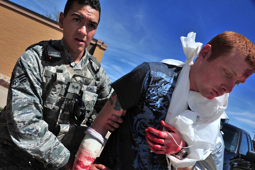 Simulated tornado victim Senior Airman Frank Jones is helped by Senior Airman Romero, 27th Special Operations Security Forces Squadron, during a natural disaster exercise at Cannon Air Force Base, N.M., April 5, 2012. Training exercises provide a safe and controlled environment to practice tactics, techniques and procedures. (U.S. Air Force photo by Tech. Sgt. Josef Cole)