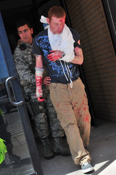 Simulated tornado victim Senior Airman Frank Jones is helped by Senior Airman Romero, 27th Special Operations Security Forces Squadron, during a natural disaster exercise at Cannon Air Force Base, N.M., April 5, 2012. Training exercises provide a safe and controlled environment to practice tactics, techniques and procedures. (U.S. Air Force photo by Tech. Sgt. Josef Cole)