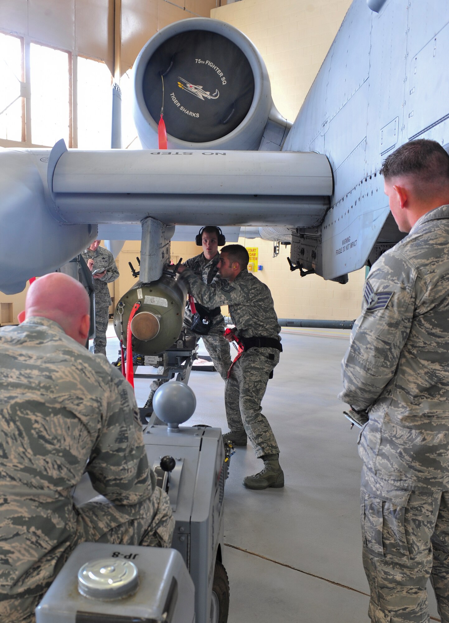 U.S. Air Force Tech. Sgt. Joshua Fiasco, center right, Airman 1st Class Trenton Metyk, and A1C Kyle Taghon, left, 23d Aircraft Maintenance Squadron, 75th Aircraft Maintenance Unit weapons load crew members, load a bomb to an A-10C Thunderbolt II during the quarterly weapons  load crew competition at Moody Air Force Base, Ga., April 13, 2012. The crew competed against a team from the 74th AMU, both with goals to quickly and safely load all the munitions without demerits. (U.S. Air Force photo by Staff Sgt. Stephanie Mancha/Released)
