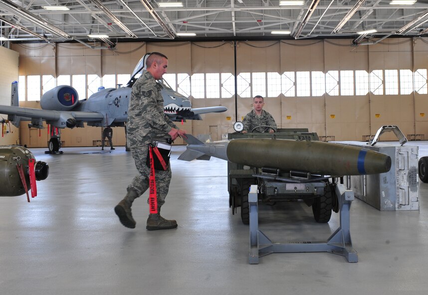 U.S. Air Force Staff Sgt. George Lesko and Airman 1st Class Levi Adams, 23d Aircraft Maintenance Squadron, 74th Aircraft Maintenance Unit weapons load crew members, transport munitions onto an A-10C Thunderbolt II during the quarterly weapons load crew competition at Moody Air Force Base, Ga., April 13, 2012. By using a spotter to help transport munitions, load crews ensure they complete the task safely and as quickly as possible. (U.S. Air Force photo by Staff Sgt. Stephanie Mancha/Released)

