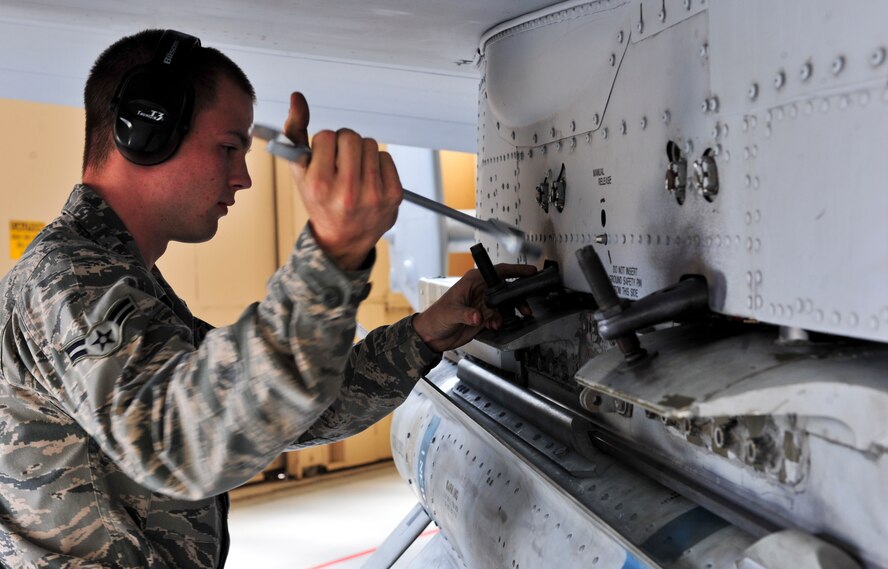U.S. Air Force Airman 1st Class Trenton Metyk, 23d Aircraft Maintenance Squadron, 75th Aircraft Maintenance Unit weapons load crew member, tightens bolts on a bomb attached to an A-10C Thunder Bolt II during a quarterly weapons load crew competition at Moody Air Force Base, Ga., April 13, 2012. The winner is determined by the fastest time loading munitions with the least amount of errors. (U.S. Air Force photo by Staff Sgt. Stephanie Mancha/Released)
