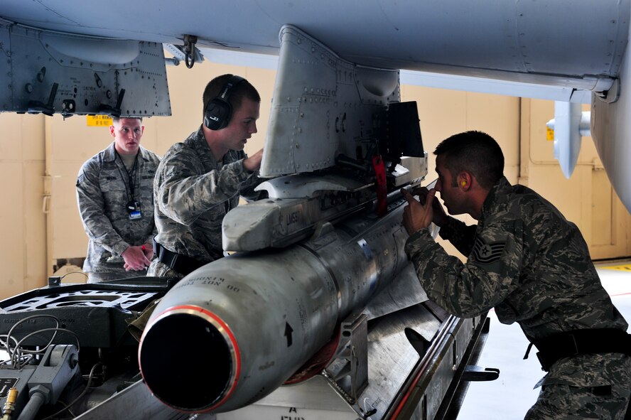 U.S. Air Force Tech. Sgt. Joshua Fiasco, right, and Airman 1st Class Trenton Metyk, 23d Aircraft Maintenance Squadron, 75th Aircraft Maintenance Unit weapons load crew members, secure a bomb onto an A-10C Thunderbolt II during a quarterly weapons load crew competition at Moody Air Force Base, Ga., April 13, 2012. Airmen from the 74th and 75th AMUs competed to load various munitions onto an A-10 the fastest and safest. Before the load-off began, the load crews underwent a 25-question job knowledge test, toolbox inspection and uniform inspection. (U.S. Air Force photo by Staff Sgt. Stephanie Mancha/Released)
