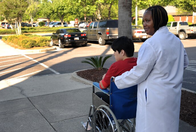 Tanya Maisonet escorts Senior Airman Chaley Dyer outside the clinic so she can be given a ride home after a wisdom tooth extraction at Joint Base Charleston - Air Base April 11. Maisonet is from the 628th Medical Group and Dyer is from the 628th Security Forces Squadron. (U.S. Air Force photo / Airman 1st Class Ashlee Galloway)